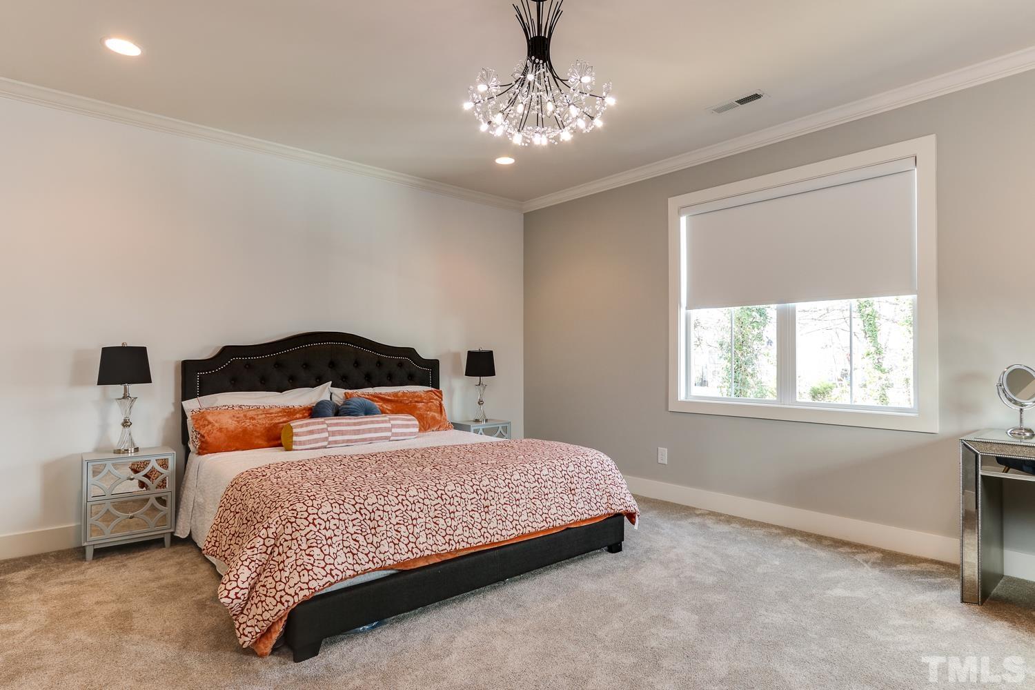 107 Revival Way Raleigh, NC 27608 - Photo 13 of 31 a bedroom with a bed and a chandelier