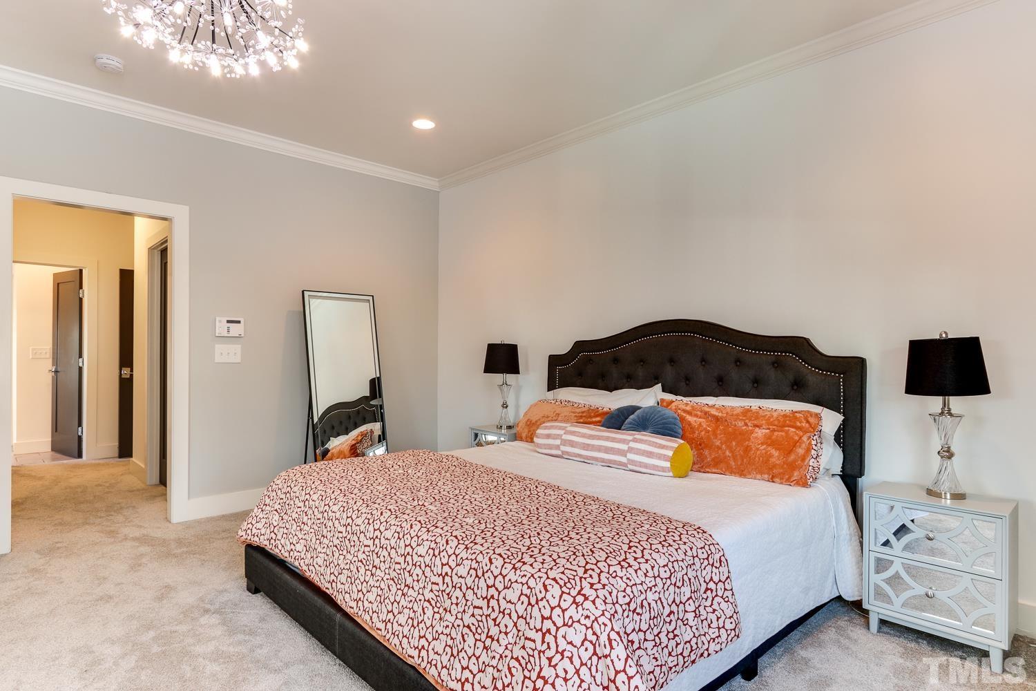 107 Revival Way Raleigh, NC 27608 - Photo 14 of 31 a bedroom with a bed and a chandelier