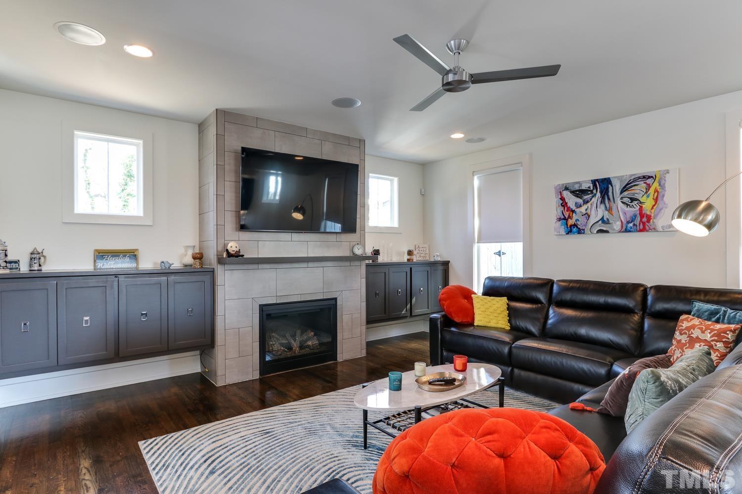 107 Revival Way Raleigh, NC 27608 - Photo 5 of 31 a living room with furniture a fireplace and a flat screen tv