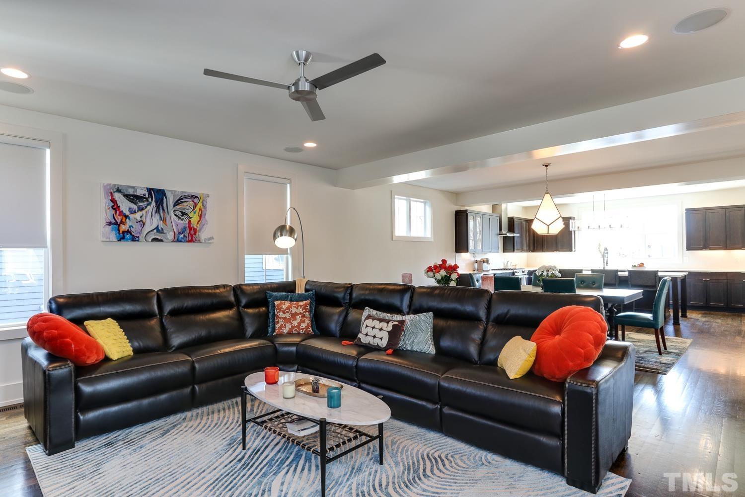 107 Revival Way Raleigh, NC 27608 - Photo 6 of 31 a living room with furniture a rug and a chandelier