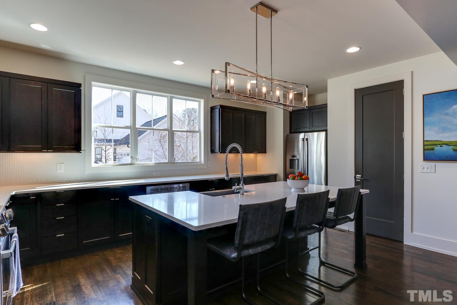 107 Revival Way Raleigh, NC 27608 - Photo 8 of 31 a kitchen with a dining table chairs sink and wooden floor