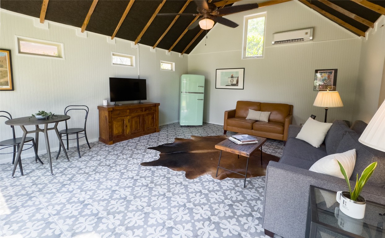 1512 Northwood Road Austin, TX 78703 - Photo 23 of 24 Living area featuring a wall mounted AC, ceiling fan, and high vaulted ceiling