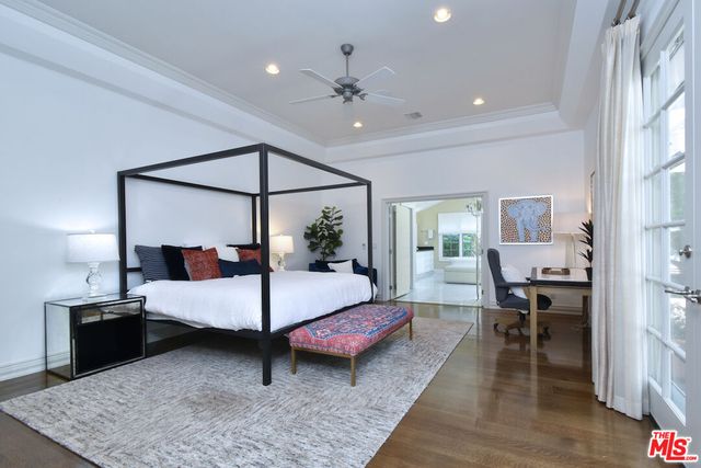 a large white kitchen with a large window and stainless steel appliances