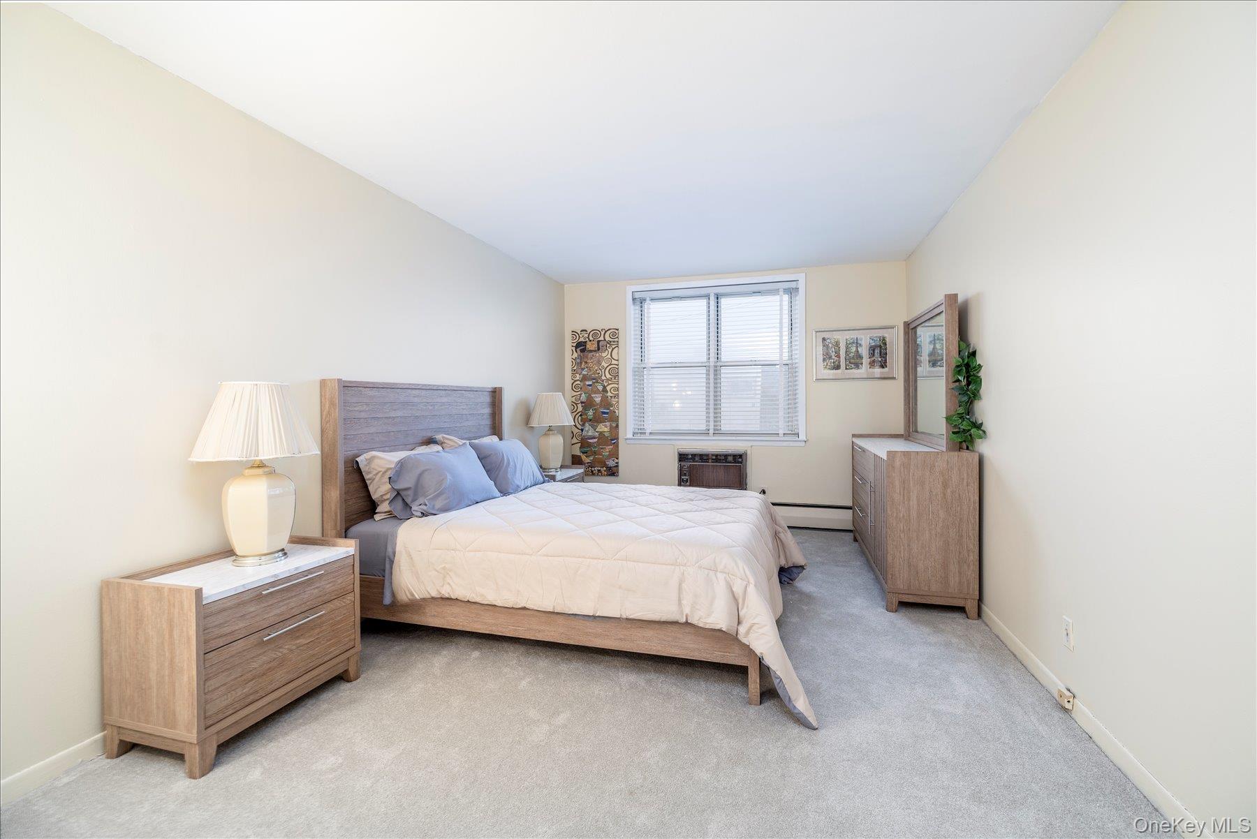 2 Fowler Avenue, Unit 211 Lynbrook, NY 11563 - Photo 11 of 19 a bedroom with bed and window