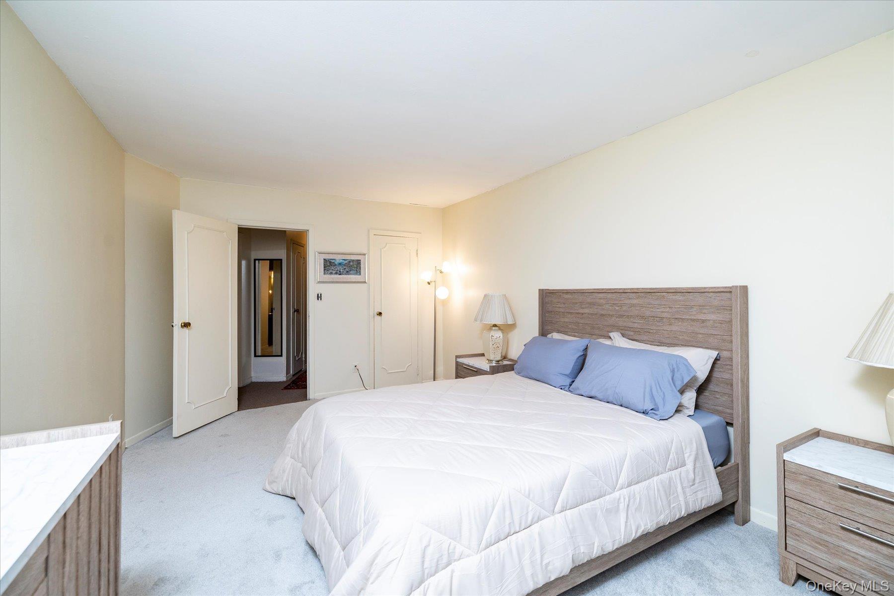 2 Fowler Avenue, Unit 211 Lynbrook, NY 11563 - Photo 12 of 19 a bedroom with a bed and a night lamp