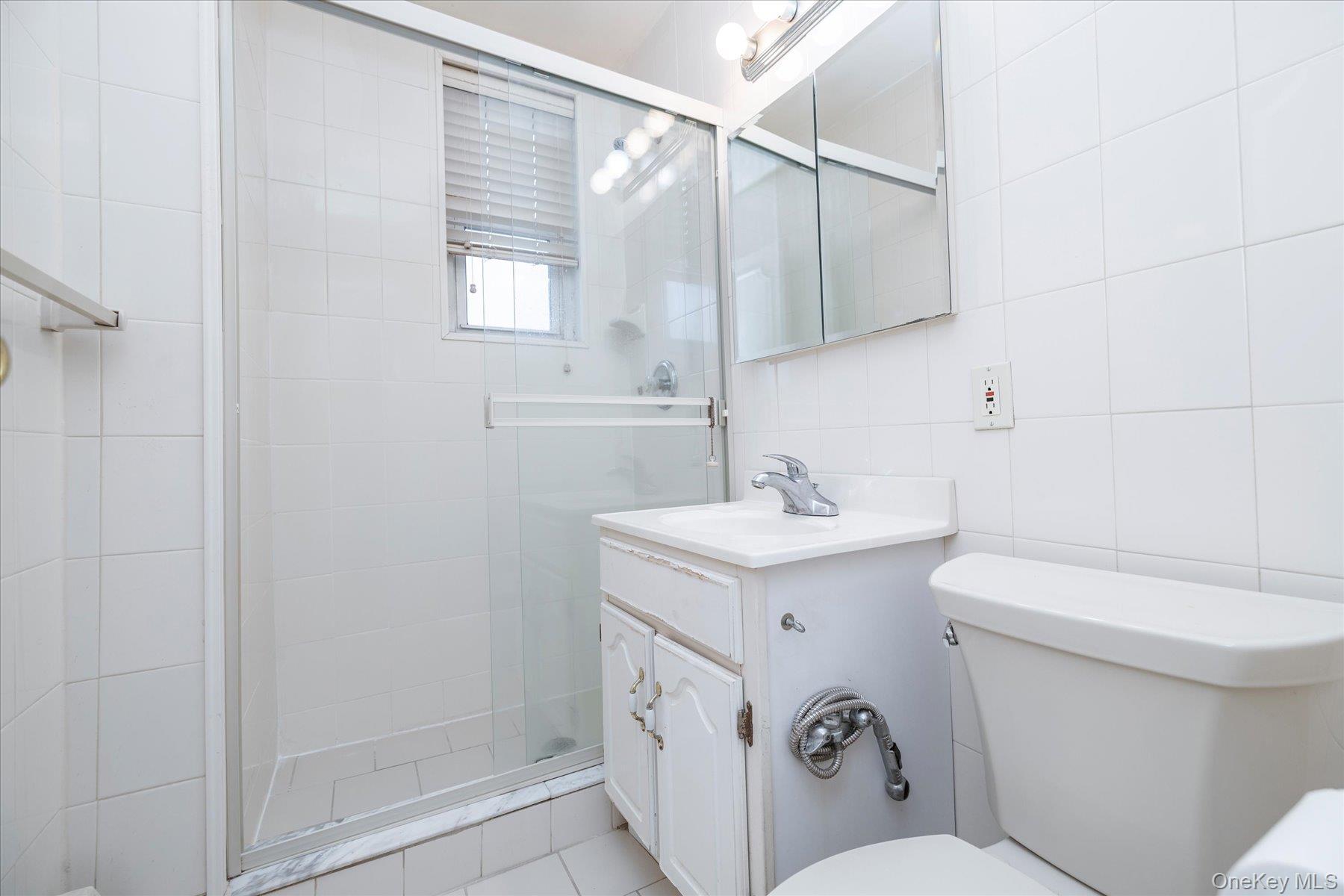 2 Fowler Avenue, Unit 211 Lynbrook, NY 11563 - Photo 13 of 19 a bathroom with a sink a toilet and shower