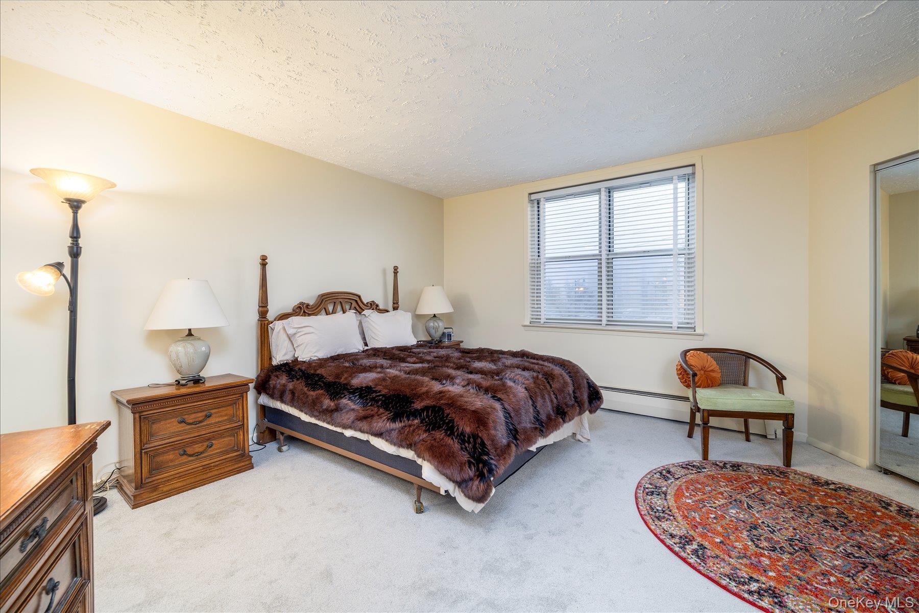 2 Fowler Avenue, Unit 211 Lynbrook, NY 11563 - Photo 15 of 19 a bedroom with a bed window and chair