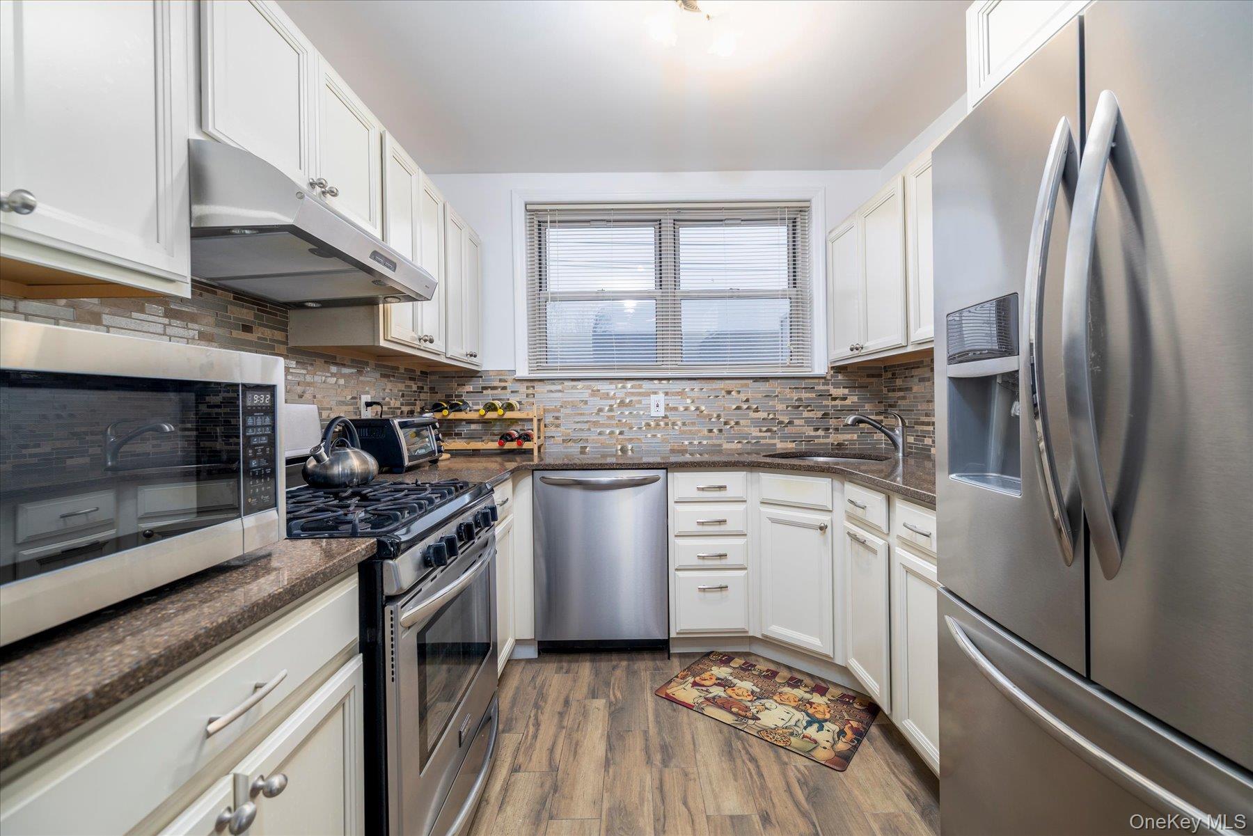 2 Fowler Avenue, Unit 211 Lynbrook, NY 11563 - Photo 3 of 19 a kitchen with stainless steel appliances granite countertop a stove a sink and a refrigerator