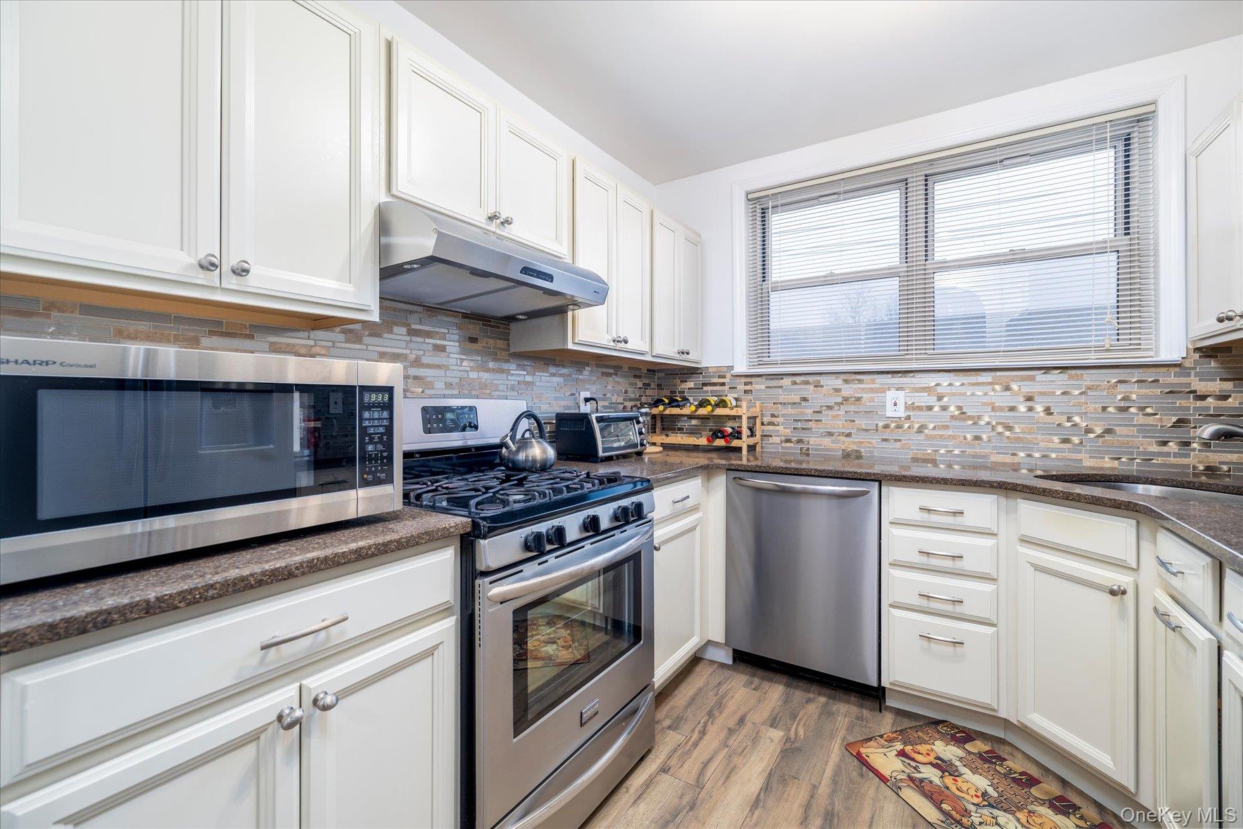2 Fowler Avenue, Unit 211 Lynbrook, NY 11563 - Photo 4 of 19 a kitchen with granite countertop cabinets stainless steel appliances and a sink