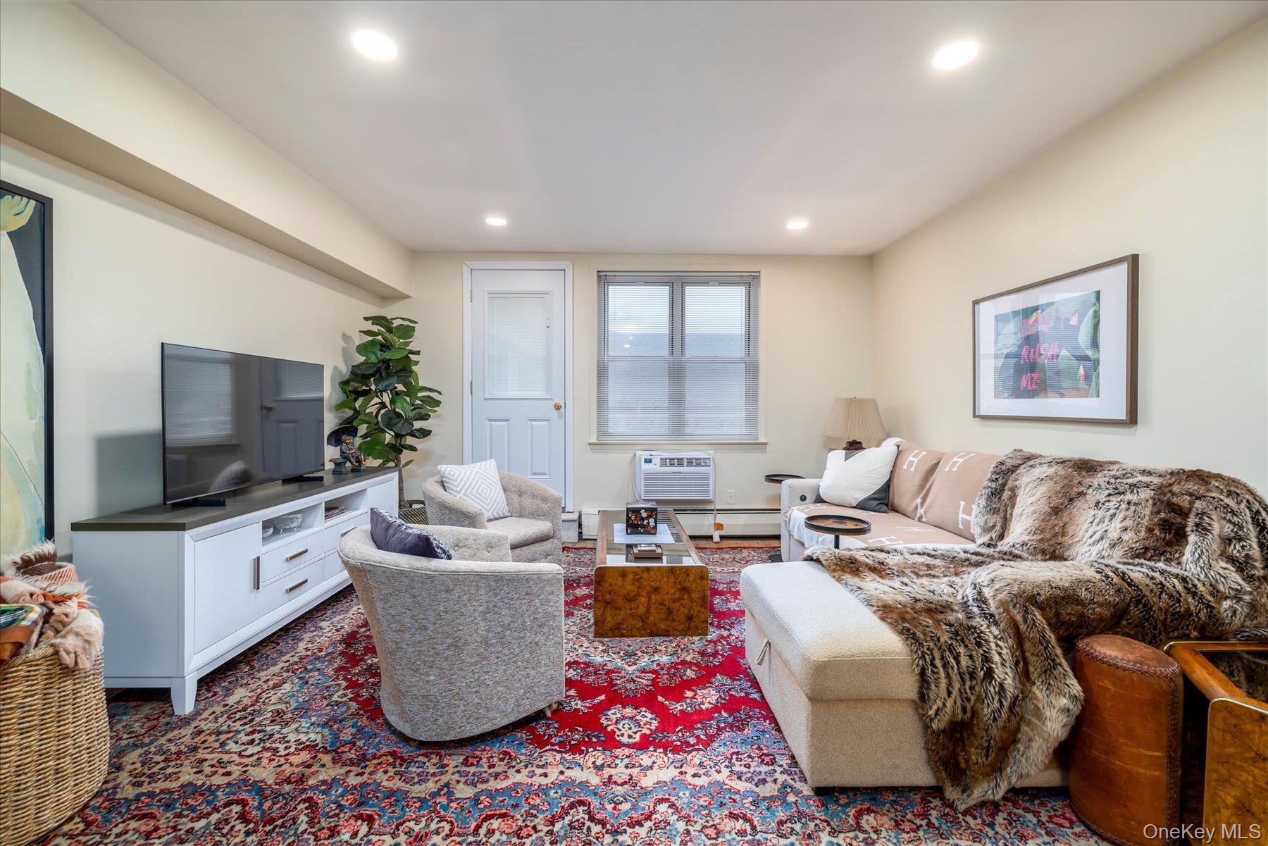 2 Fowler Avenue, Unit 211 Lynbrook, NY 11563 - Photo 7 of 19 a living room with a couch and a flat screen tv