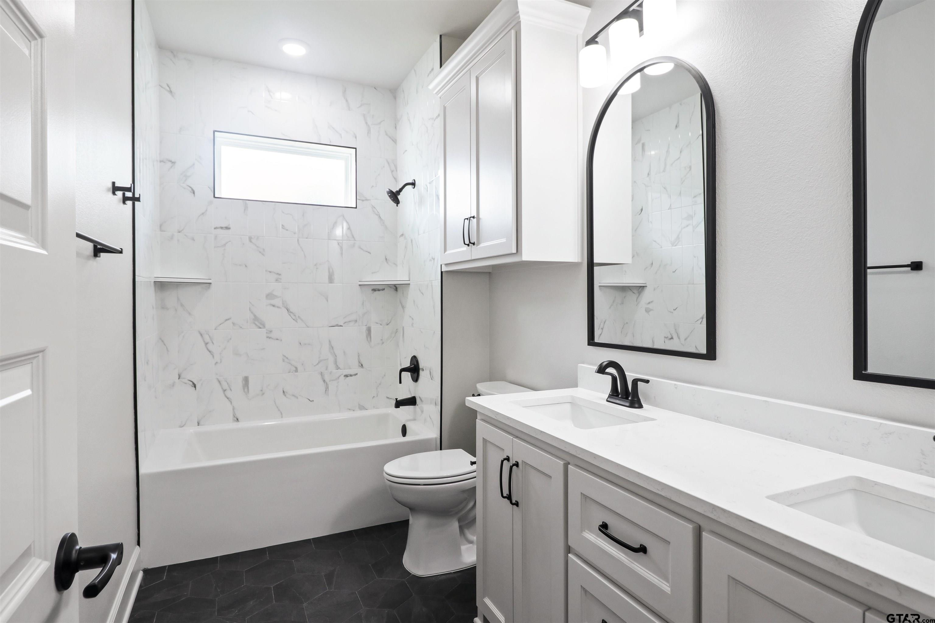15515 Sugar Ridge Lane Flint, TX 75762 - Photo 29 of 34 a bathroom with a double vanity sink toilet and shower