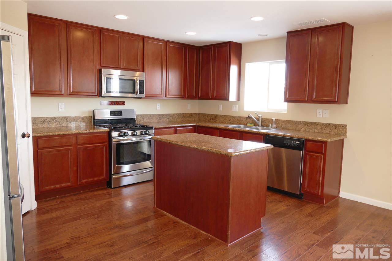 2880 Bryan Street Reno, NV 89503 - Photo 4 of 20 a kitchen with stainless steel appliances granite countertop wooden cabinets a stove a sink and a microwave