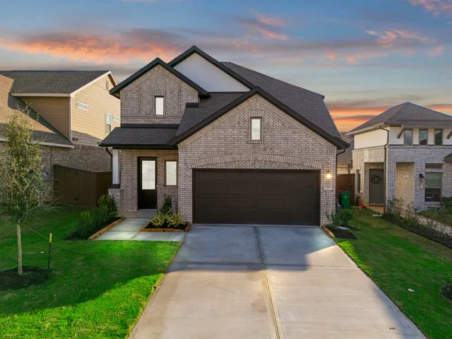 a front view of a house with a yard and trees