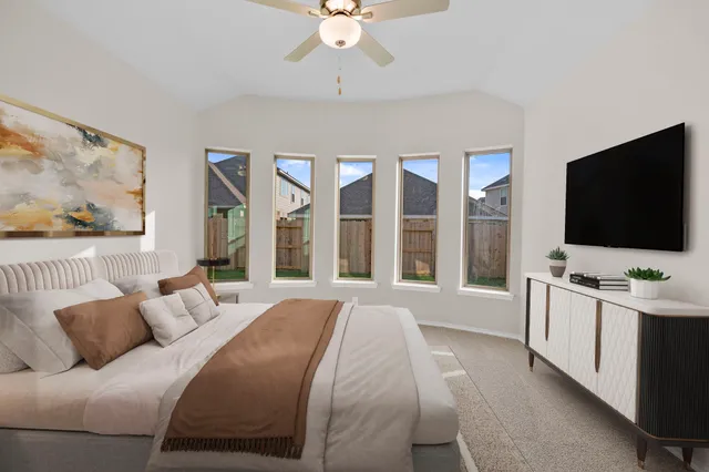 a spacious bedroom with a large bed and a flat screen tv
