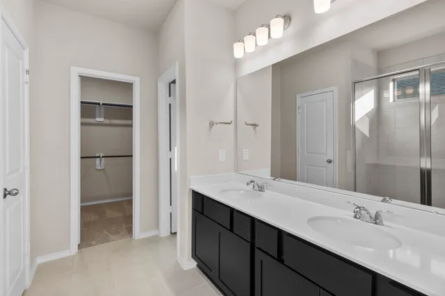 a bathroom with a double vanity sink mirror and shower
