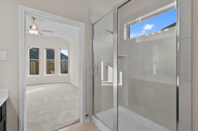 a bathroom with a glass shower door and a mirror