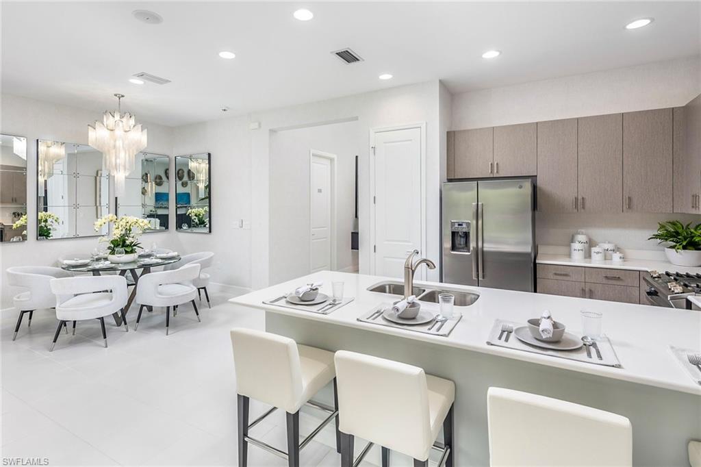 a dining room with stainless steel appliances kitchen island granite countertop a dining table and chairs