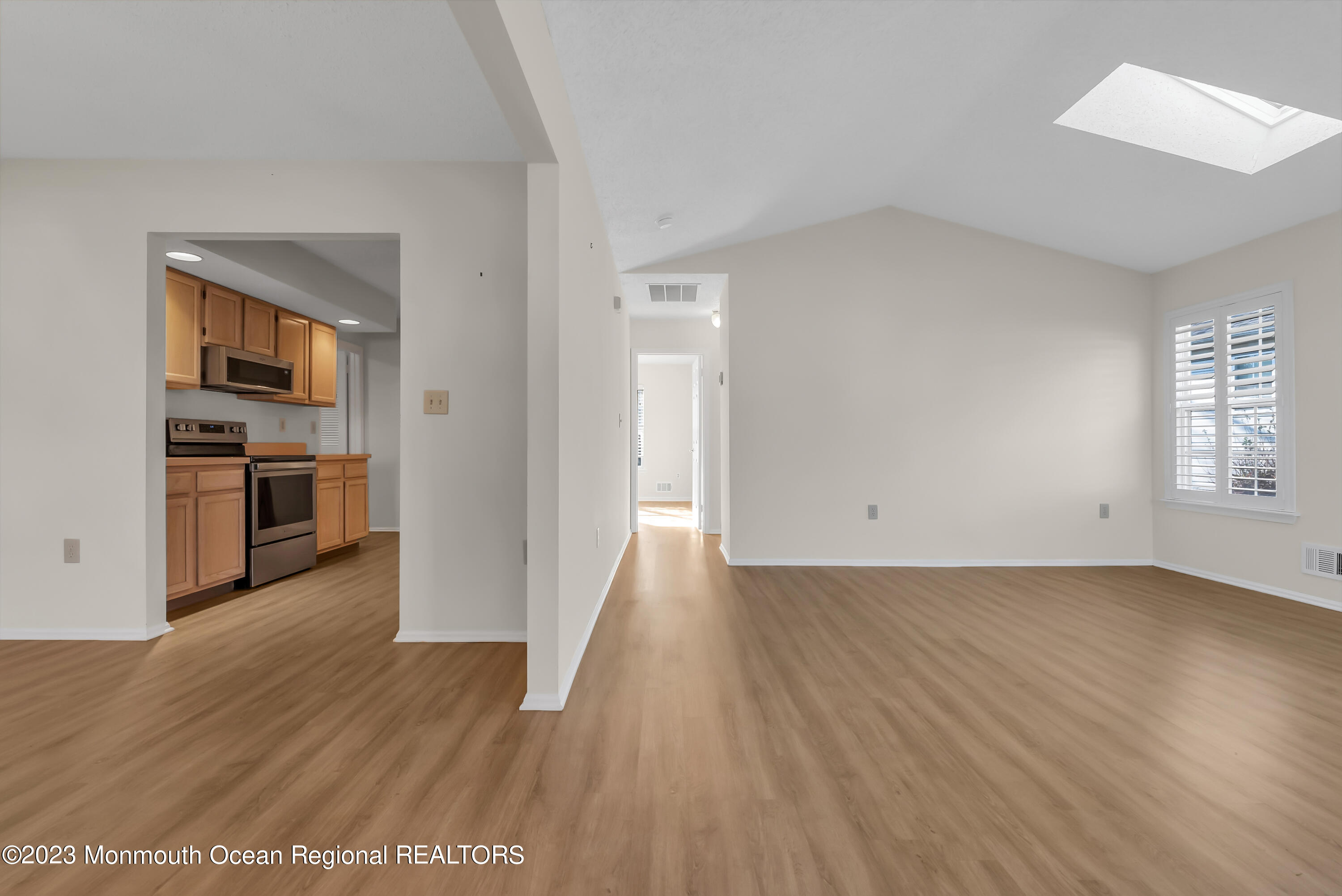 25 Cottontail Drive Brick, NJ 08724 - Photo 7 of 32 an empty room with wooden floor kitchen and windows