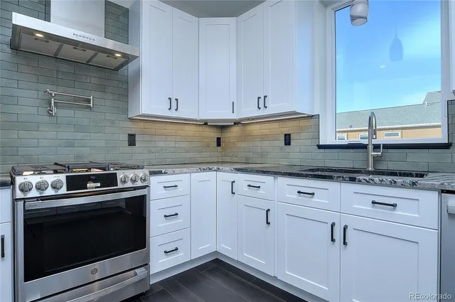 a kitchen with granite countertop white cabinets and appliances
