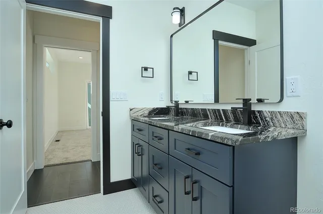 a bathroom with a granite countertop sink and a mirror