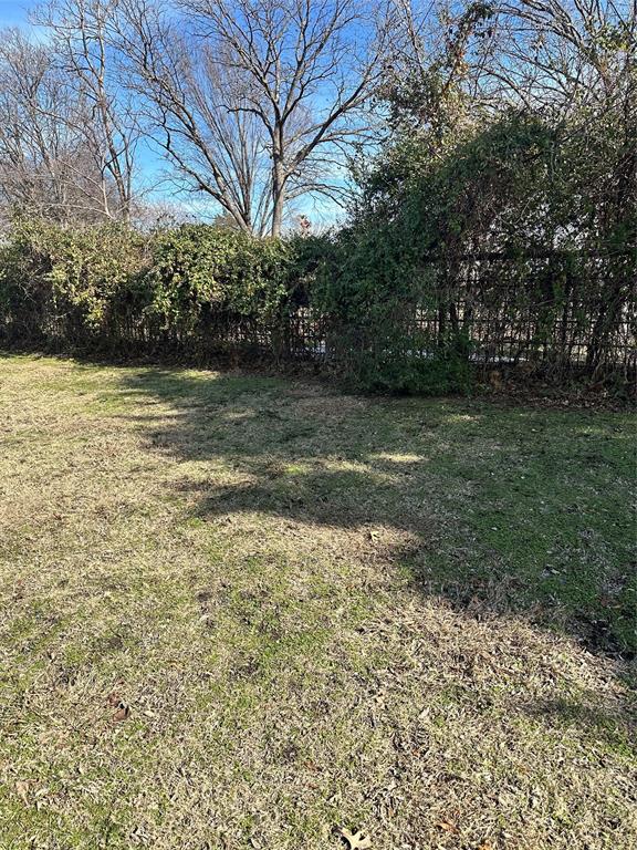2590 Rock Ridge Road Lucas, TX 75002 - Photo 2 of 25 Expansive outdoor space featuring a partial chain-link fence, established perimeter shrubbery, mature trees, and a grass lawn