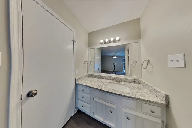 a bathroom with a granite countertop sink and a mirror