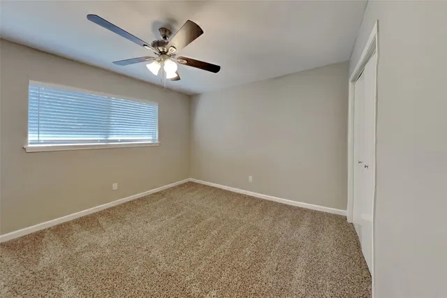 a view of an empty room with a ceiling fan