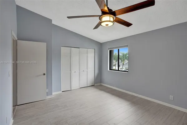 an empty room with closet and a chandelier fan
