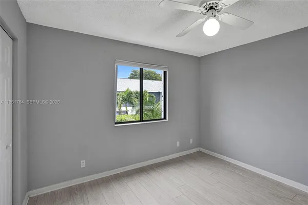 an empty room with a window and a fan