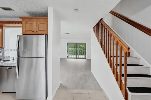 a view of a kitchen with wooden floor and staircase