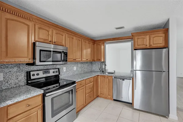 a kitchen with a refrigerator and a stove top oven