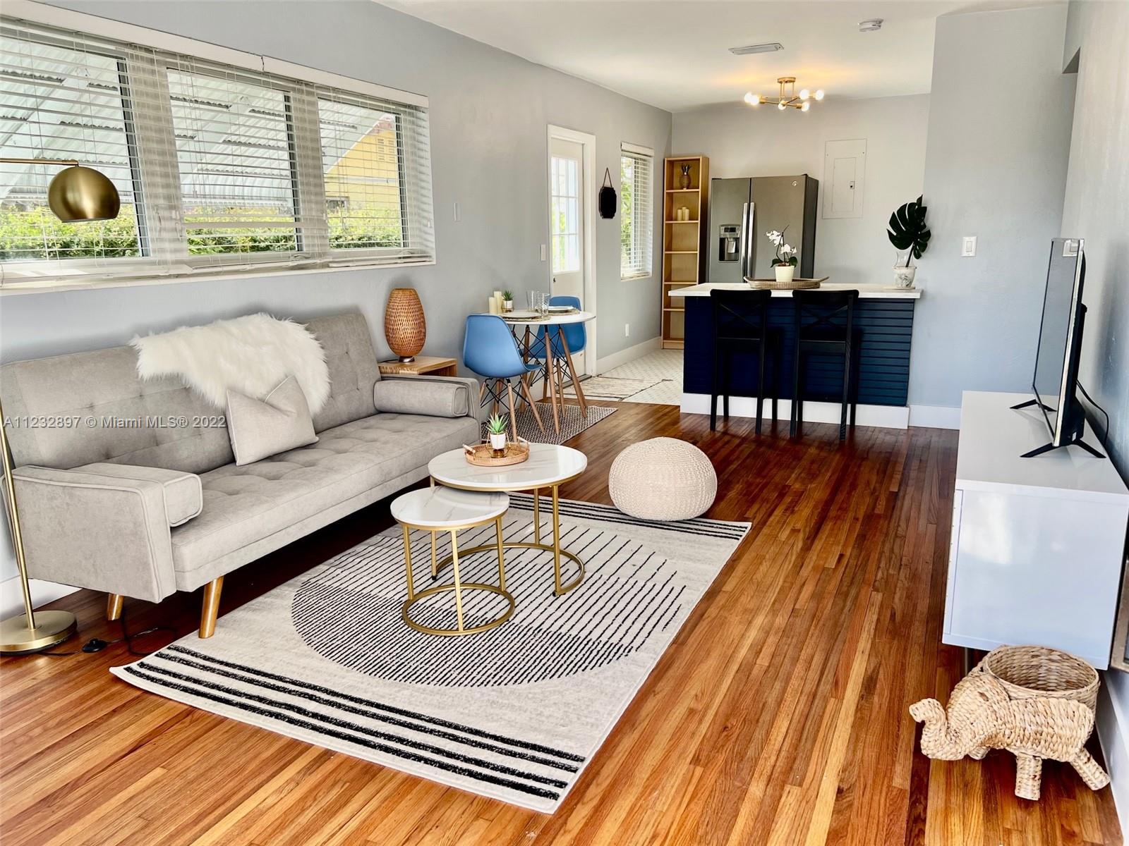 a living room with furniture and wooden floor