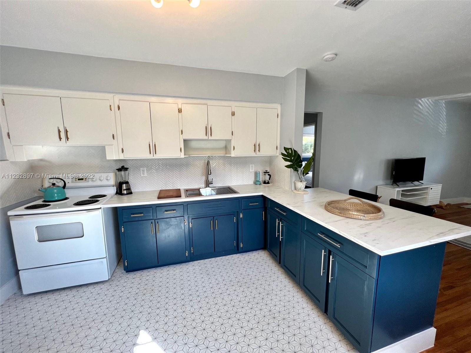 3095 Southwest 21st Street, Unit 1 Miami, FL 33145 - Photo 6 of 15 a kitchen with stainless steel appliances granite countertop a stove a sink dishwasher and a refrigerator with white cabinets