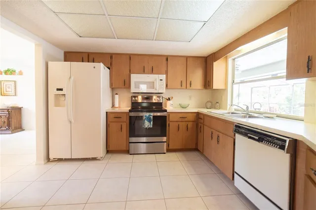 a kitchen with a refrigerator a sink and white cabinets