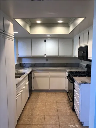 a kitchen with granite countertop a stove top oven sink and cabinets