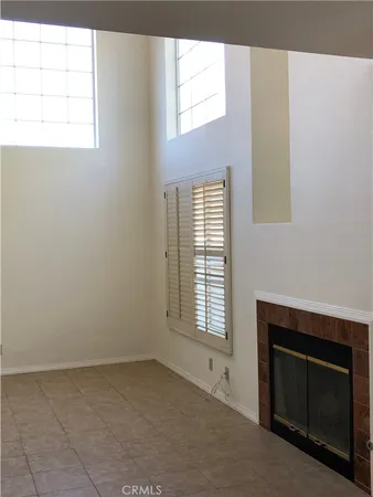 a view of an empty room with a window and fireplace