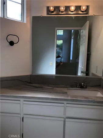 a bathroom with a granite countertop toilet and a sink