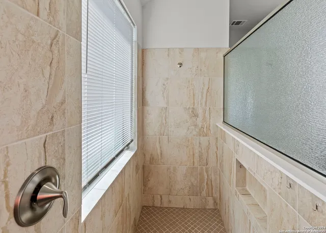 a bathroom with a shower and a window