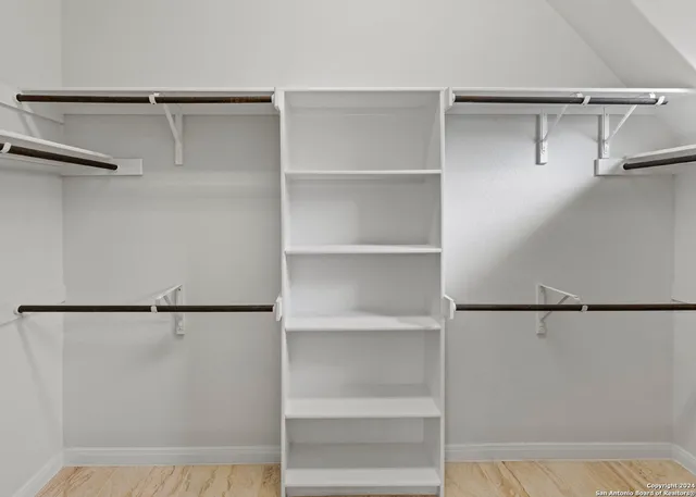 a view of walk in closet with empty racks