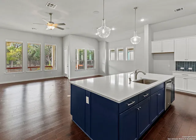 a kitchen with a center island wooden floor and a large window