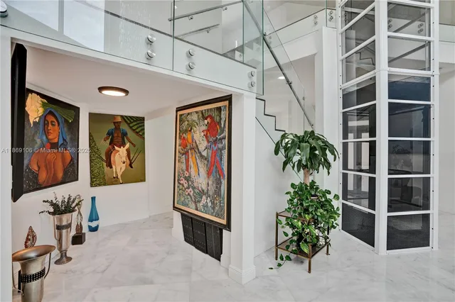 a living room with furniture a potted plant and a large window