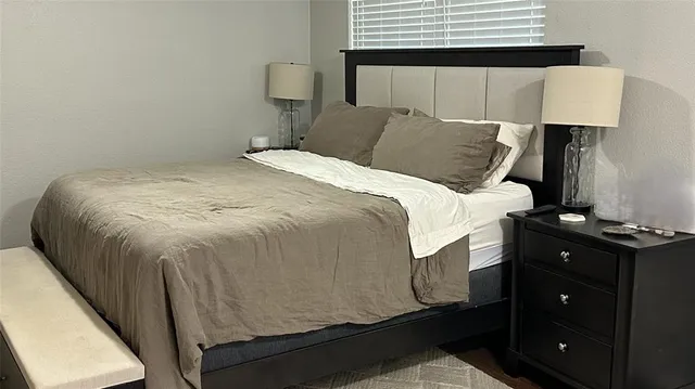 a bedroom with a bed and a night stand