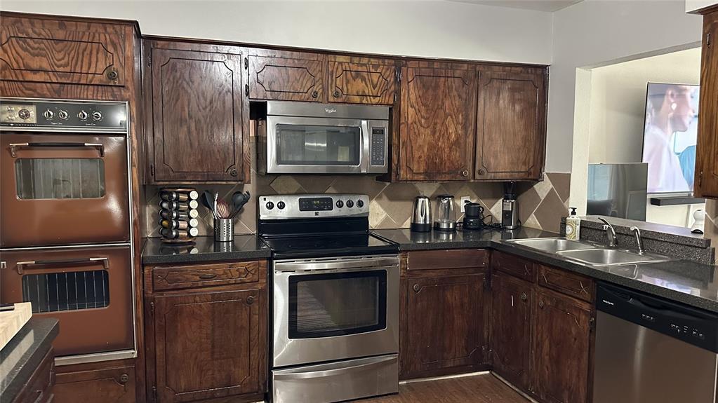 13533 Emeline Street Farmers Branch, TX 75234 - Photo 10 of 29 a kitchen with stainless steel appliances granite countertop a stove microwave and refrigerator