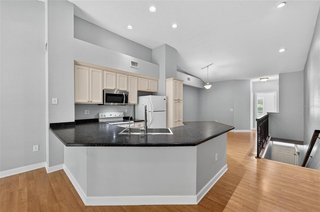 820 Normandy Trace Road Tampa, FL 33602 - Photo 20 of 49 a kitchen with kitchen island stainless steel appliances a sink a microwave a refrigerator and cabinets