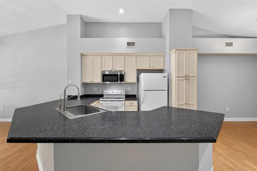 820 Normandy Trace Road Tampa, FL 33602 - Photo 21 of 49 a kitchen with kitchen island granite countertop a sink a stove and refrigerator