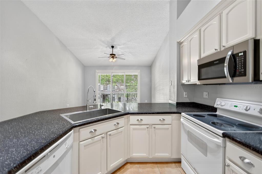 820 Normandy Trace Road Tampa, FL 33602 - Photo 23 of 49 a kitchen with stainless steel appliances granite countertop a sink a stove a microwave and cabinets