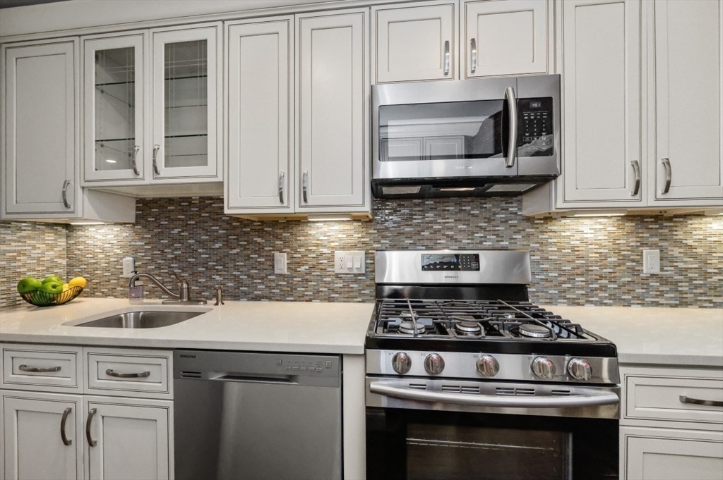 1880 Beacon Street, Unit 6 Brookline, MA 02445 - Photo 8 of 18 a kitchen with stainless steel appliances granite countertop a stove and a microwave