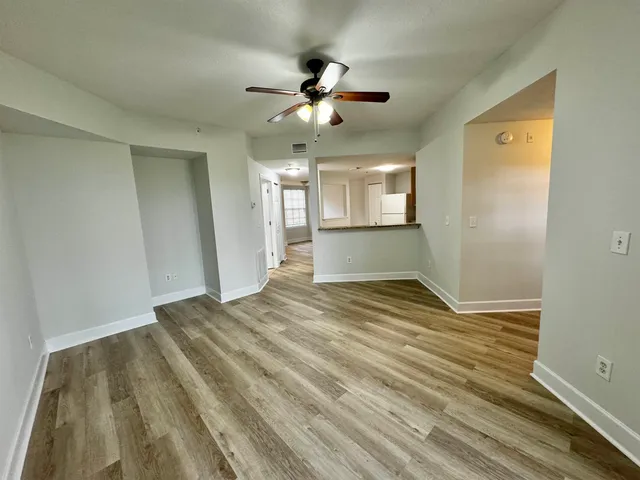 a view of empty room with window and ceiling fan