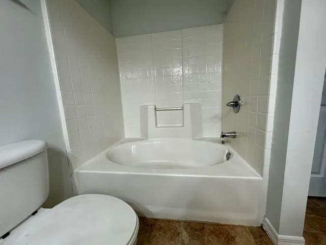 a white bath tub sitting next to a toilet