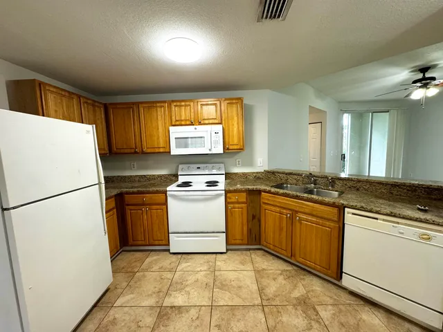 a kitchen with a refrigerator sink stove and cabinets